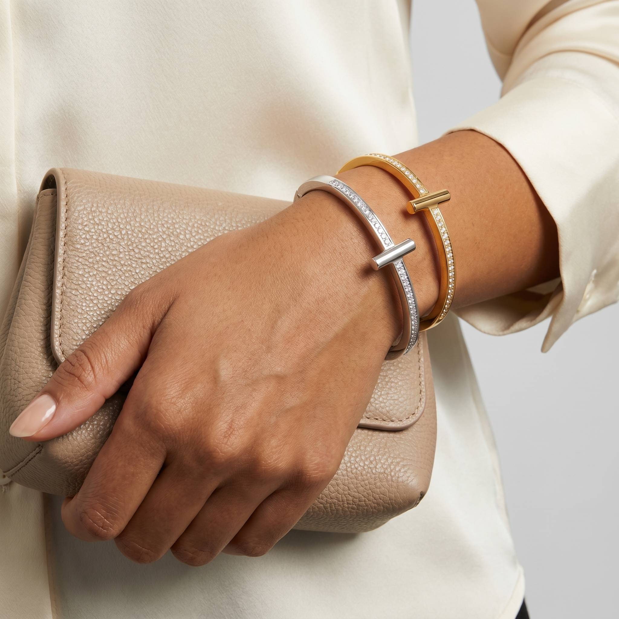Dois braceletes no pulso de uma modelo segurando bolsa