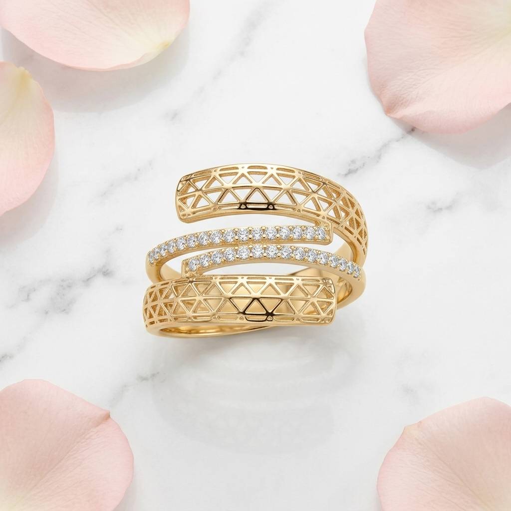 Anel espiral dourado sobre mármore branco com pétalas de rosa